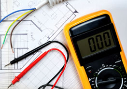 Electrical voltage meter resting on residential blueprint plans.
