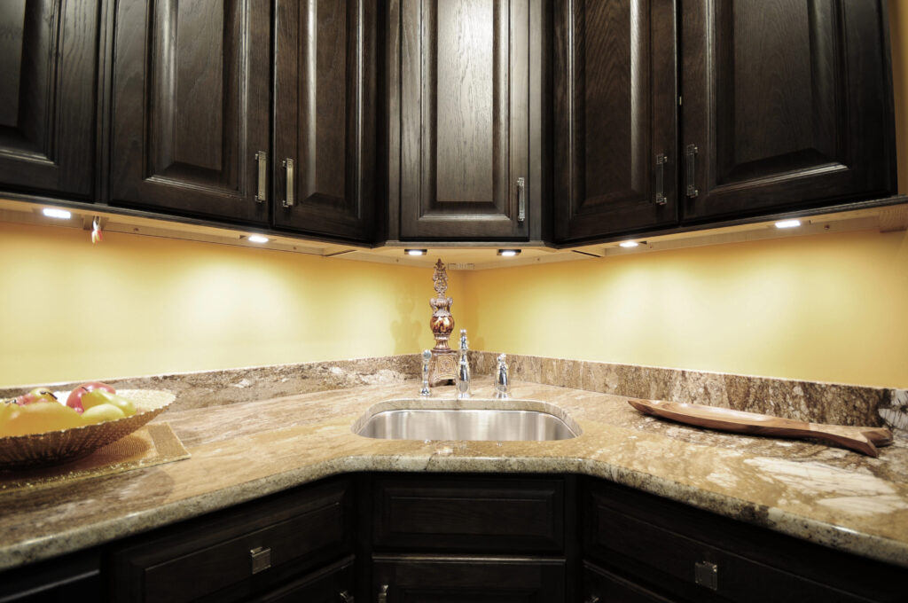 A kitchen with dark cabinets and a sink